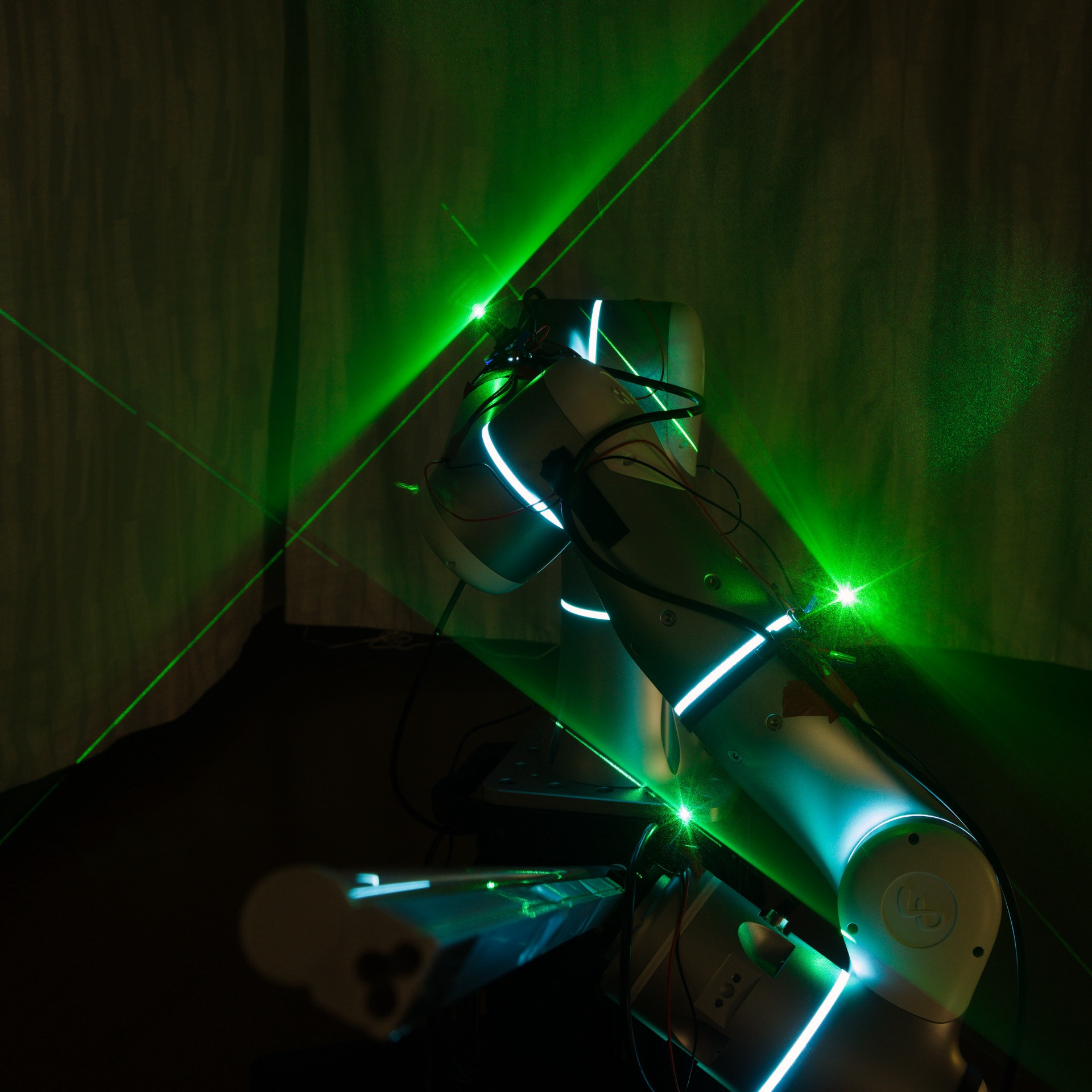 Detail view of the robot joint illuminated by crossing green laser lines