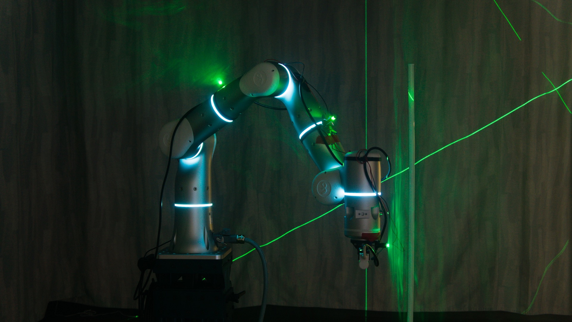 Green laser planes crossing the robot arm during the second stage of the performance